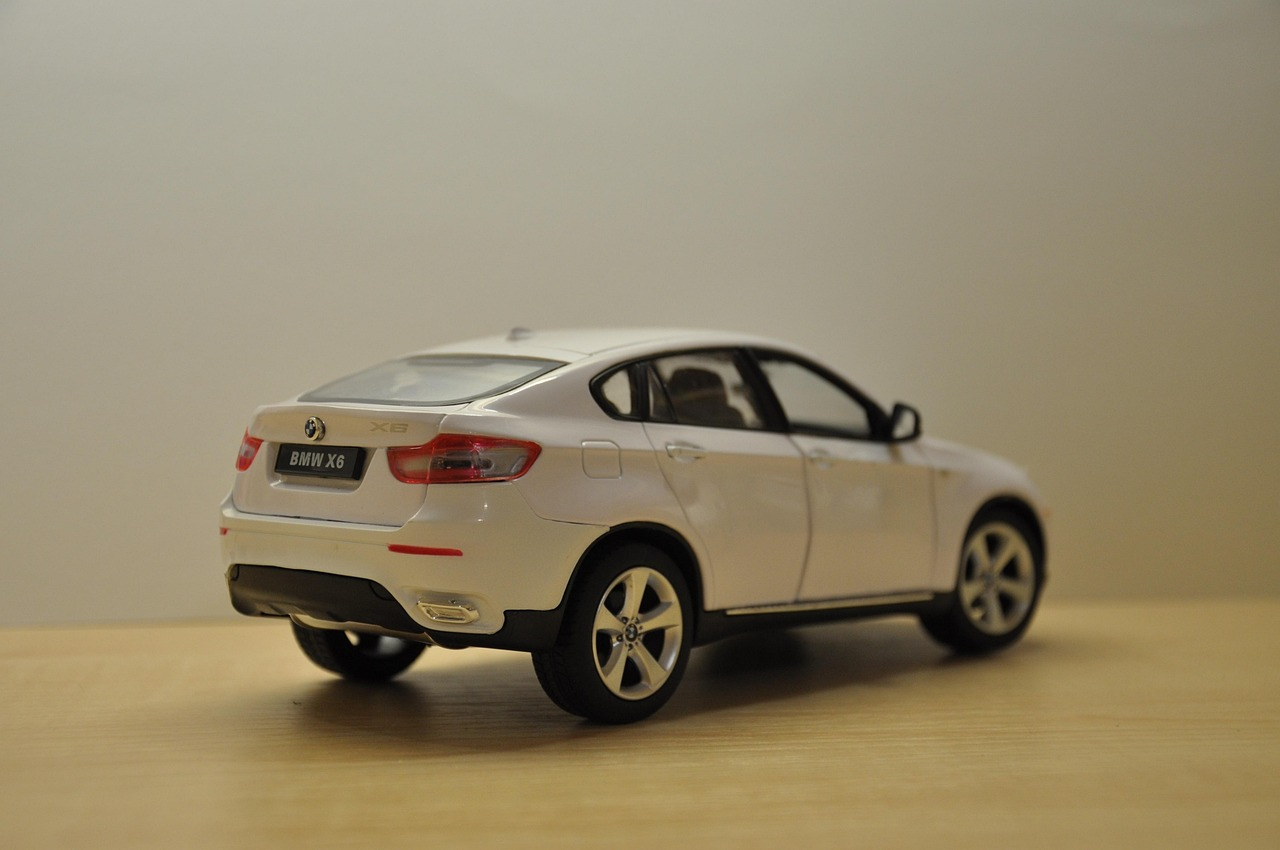 White BMW X6 model car on wooden surface