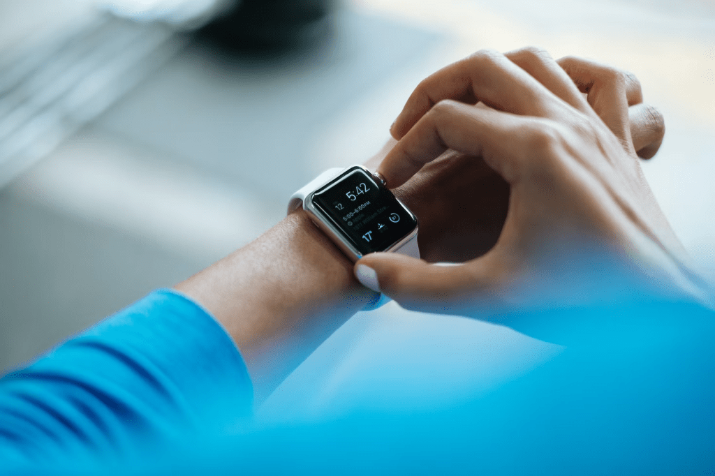 A person adjusting the settings on a smartwatch, with a close-up view of their hand and wrist.
