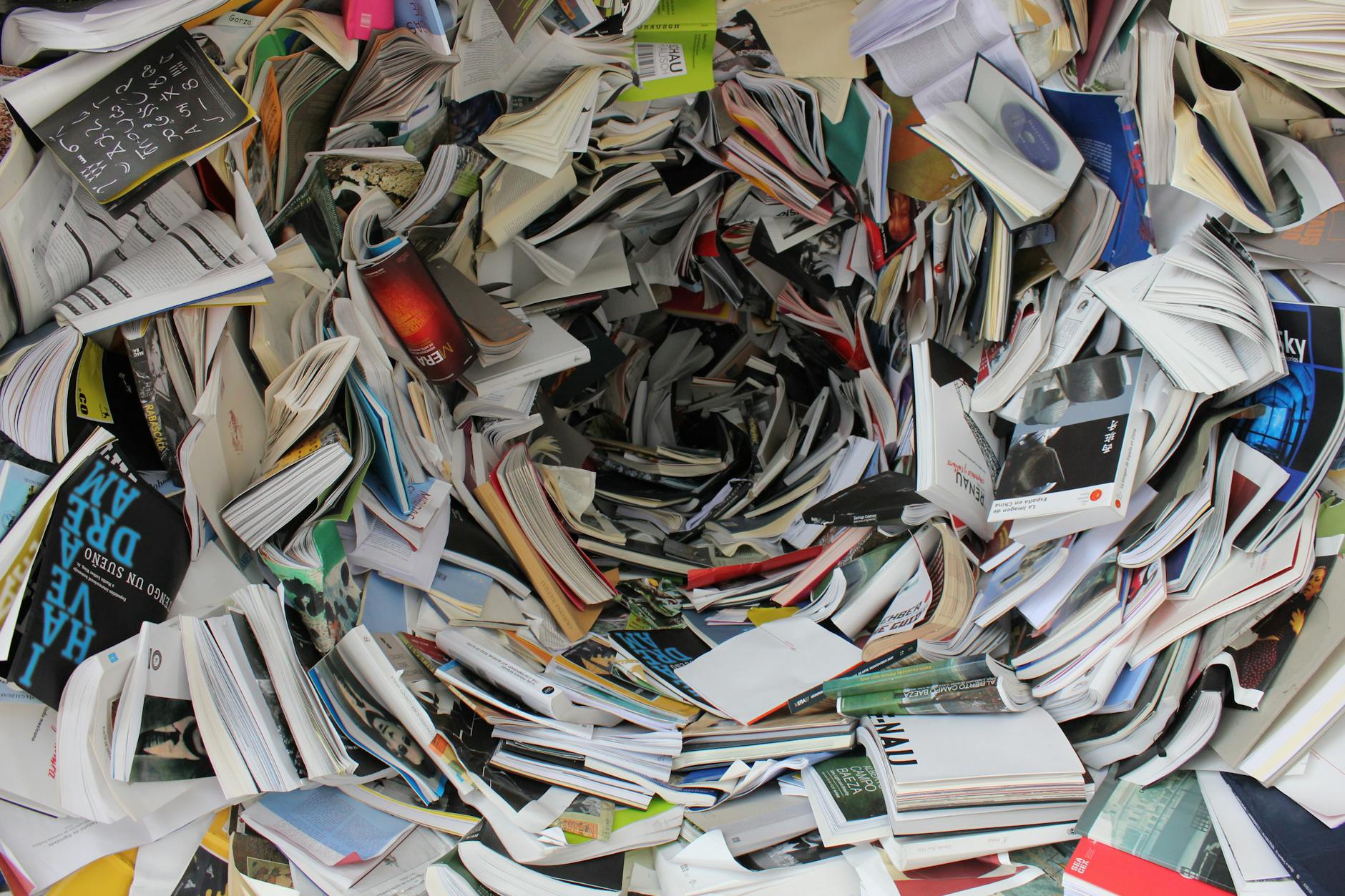 A chaotic pile of disorganized books and papers swirling in a vortex, exemplifying clutter and chaos.