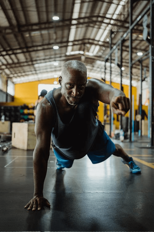 An older man performing push-ups in a gym, showcasing strength and determination.