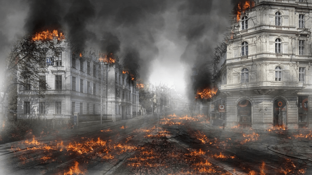 A desolate street scene featuring burning buildings and smoke rising into the air, with flames spreading along the ground and damage evident on the structures.