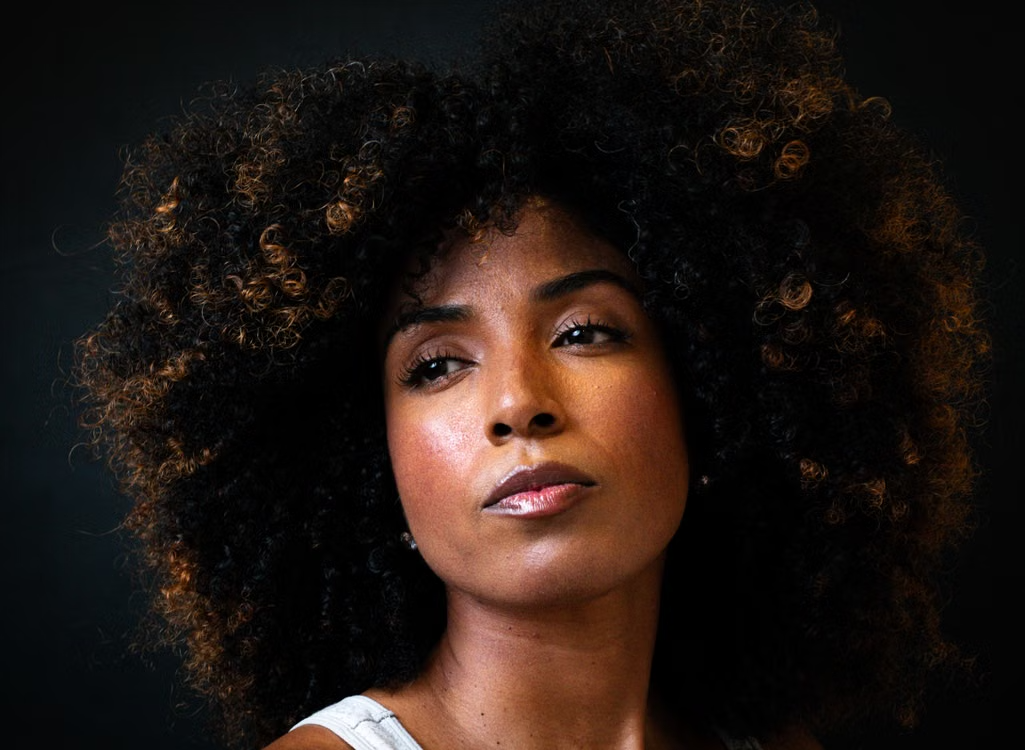 Portrait of a woman with large curly hair looking off-camera